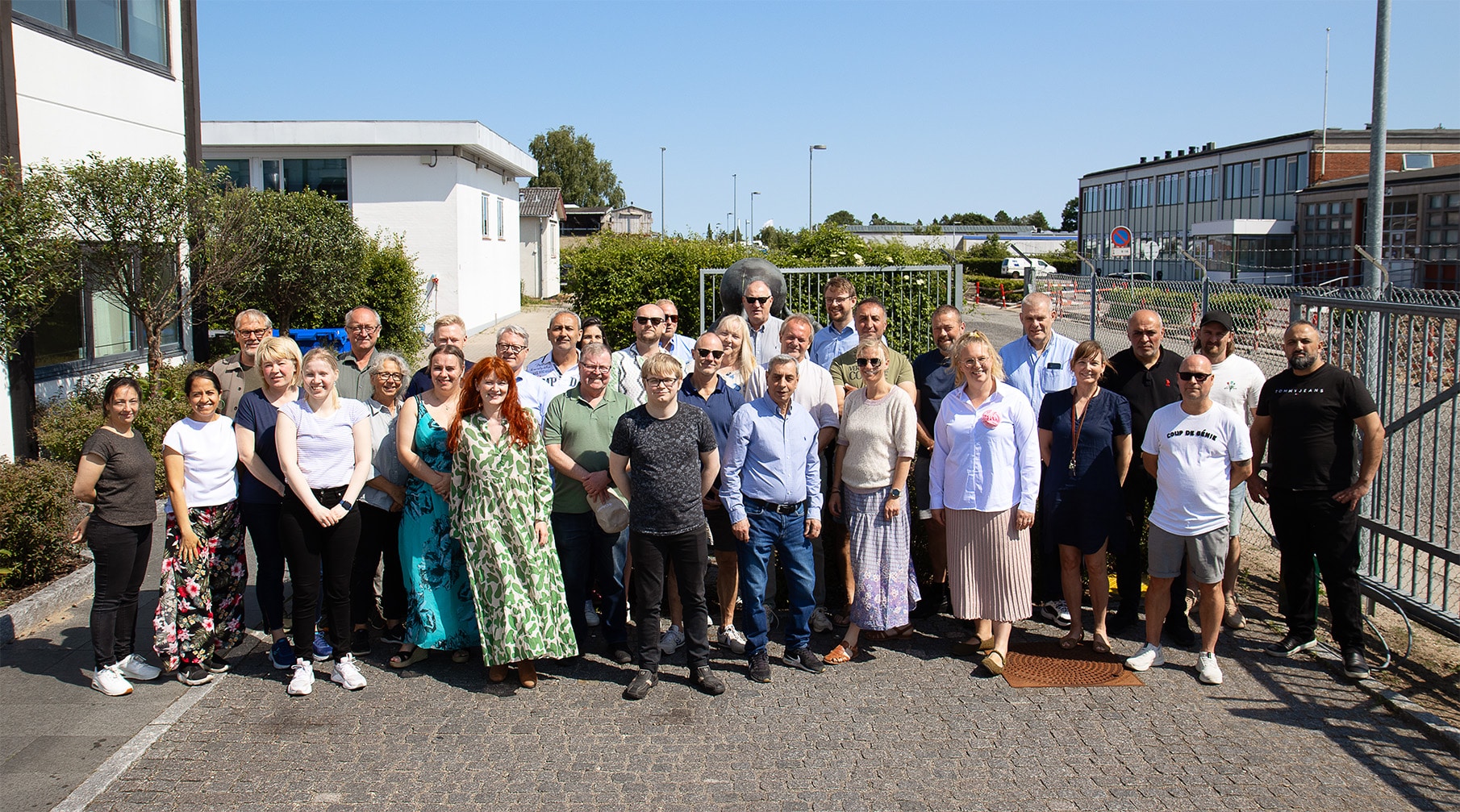 Employees at Resino Inks gathered outside the company headquarters on a sunny day.